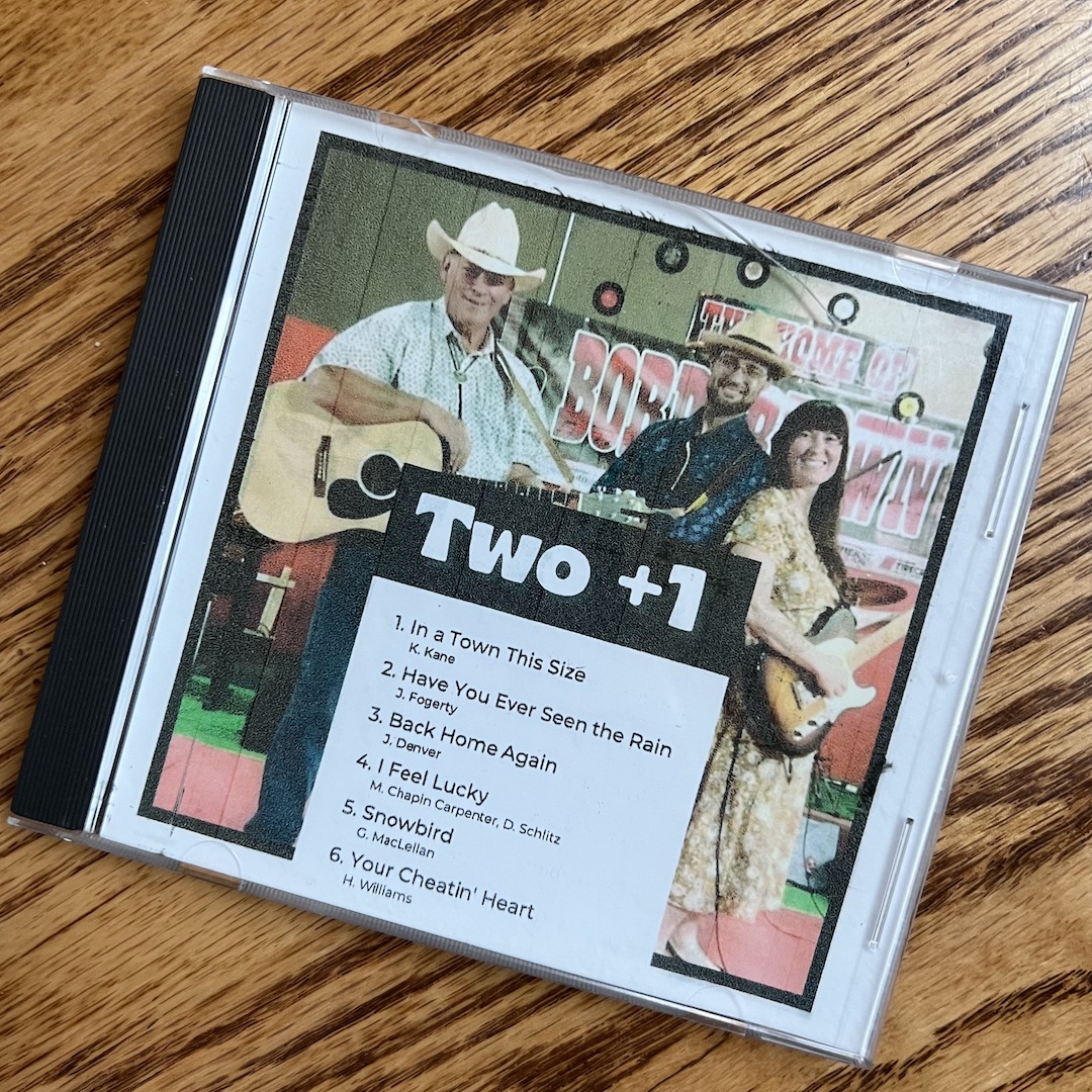 Two +1 CD case on wood table Demo: In the Shop